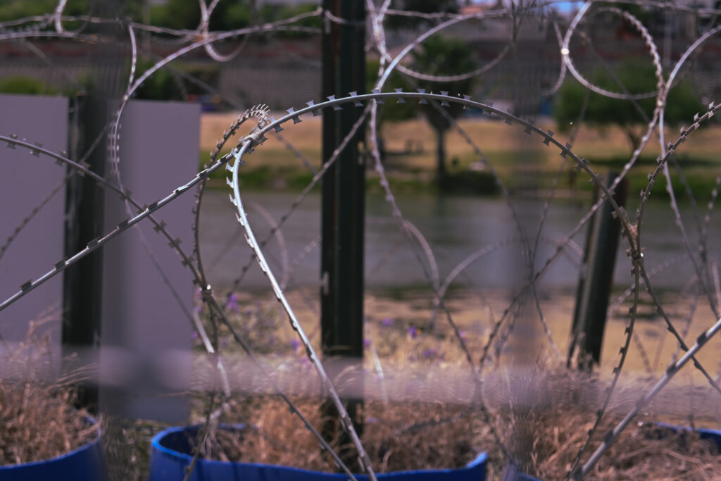 A close up of rusted concertina wire, or razor wire. The wire has caused countless injury to those who attempt to cross through it.